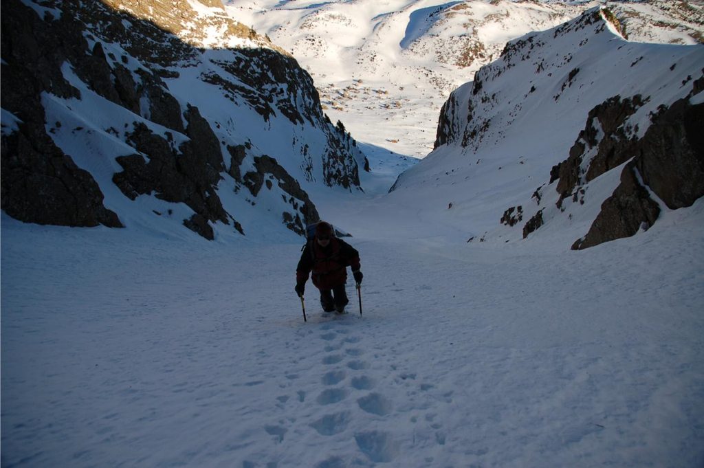 Alpinista en un corredor invernal en Pirineos
