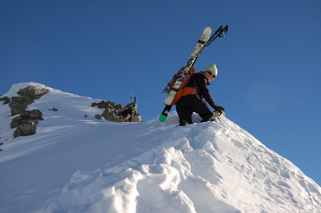 Esquiadora de montaña progresando en terreno invernal.